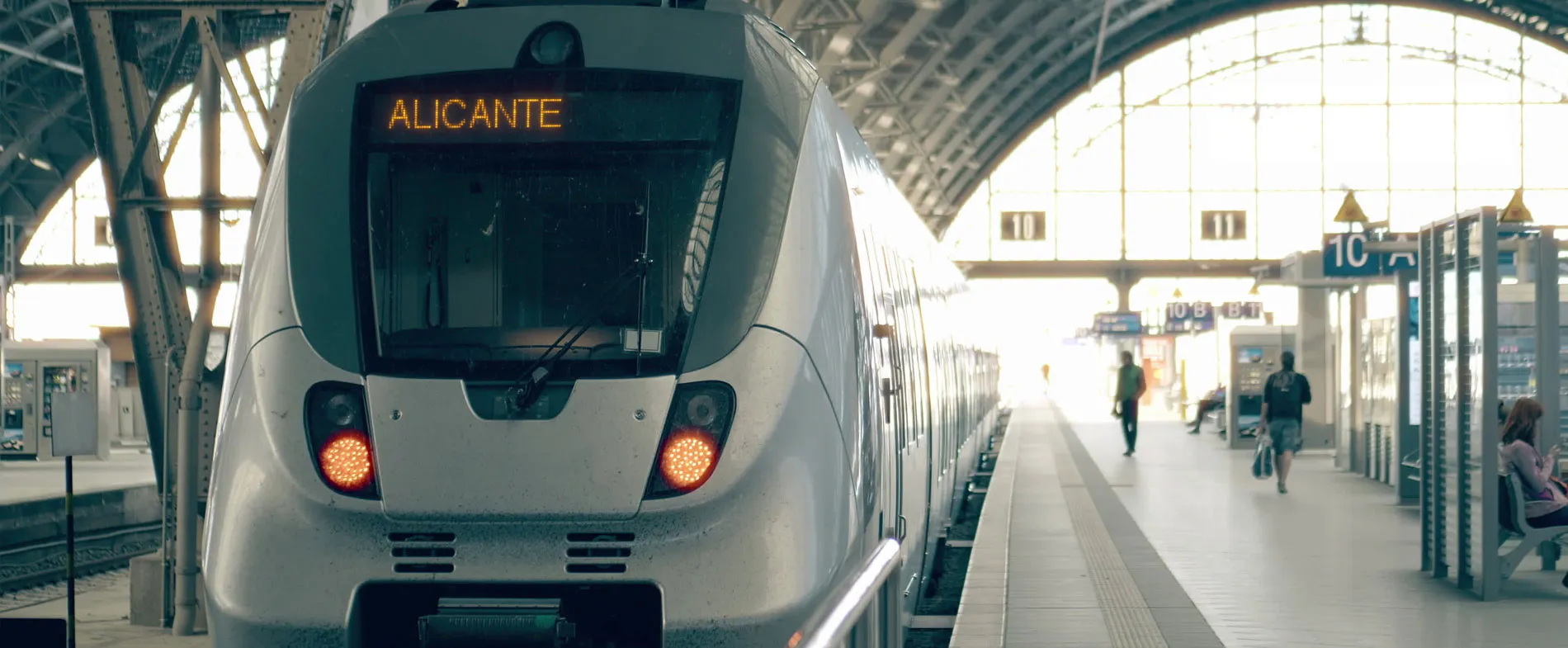Rampă de tren cu tren modern pregătit de plecare spre Alicante într-o gară luminoasă.