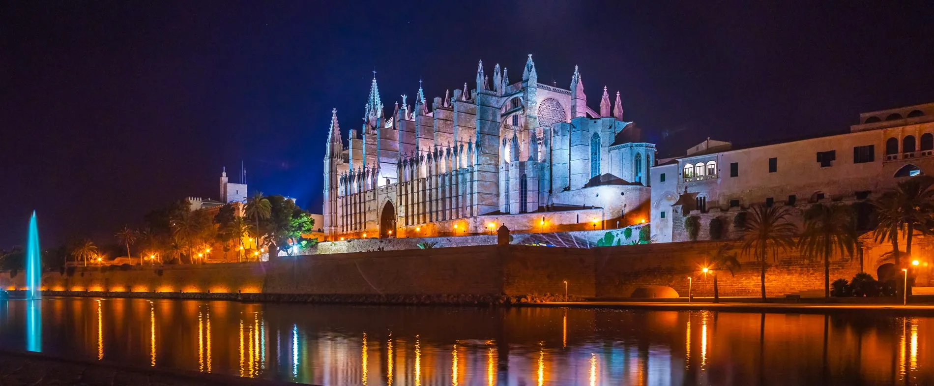 Cattedrale di Palma illuminata di notte con riflessi sull'acqua a Maiorca, Spagna.