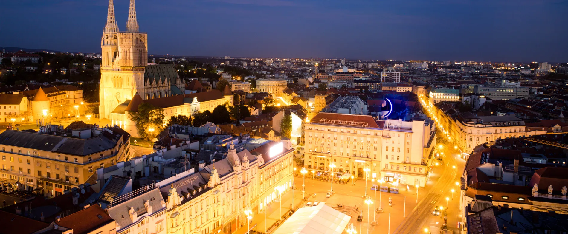 Zagreb city center at night with illuminated cathedral and lit streets, ideal for car rental trips.