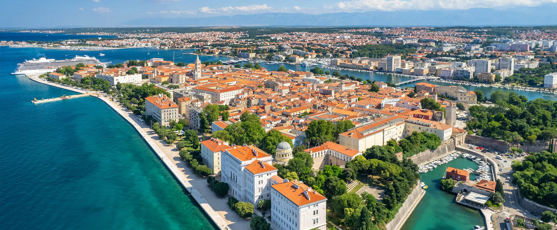 Zadar old town coastline with red roofs and a cruise ship in the Adriatic Sea for travel and car rental.