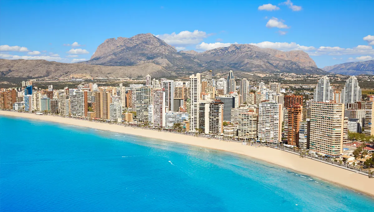 Orizont Benidorm cu plajă cu nisip și mare albastru sub cer senin lângă munți în Spania.