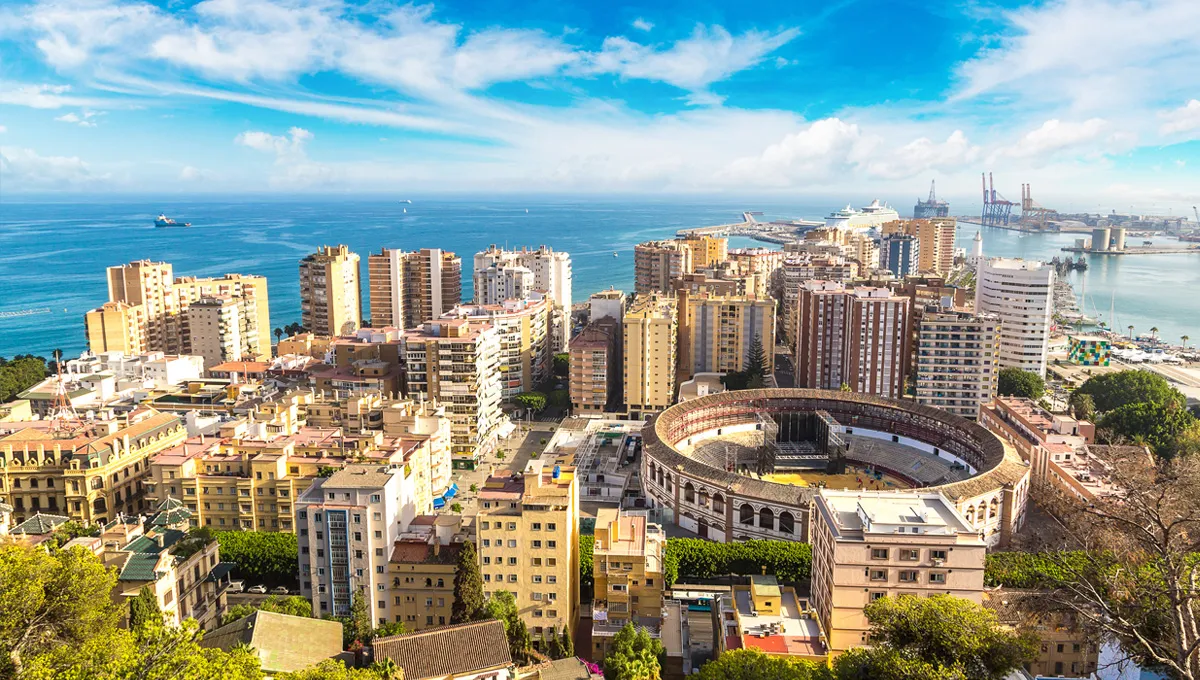 Panorama orașului Málaga cu clădiri, arenă istorică și țărm albastru.
