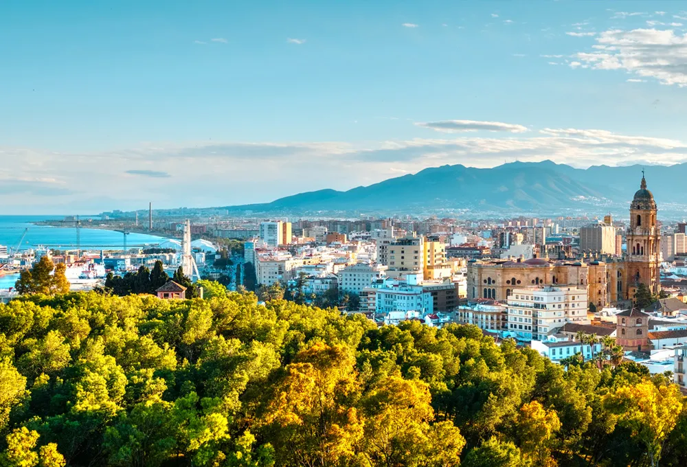 Peisaj urban din Malaga cu coastă și munți, destinație ideală pentru închirieri auto.