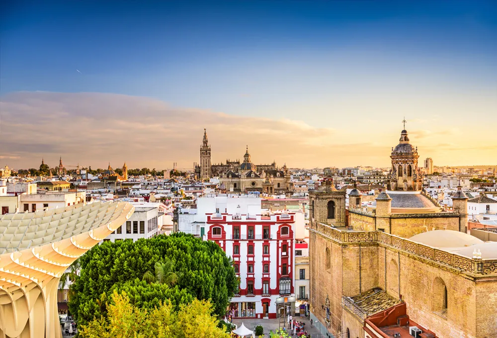 Seville city skyline with historic buildings and modern architecture at sunset for car rental travel.