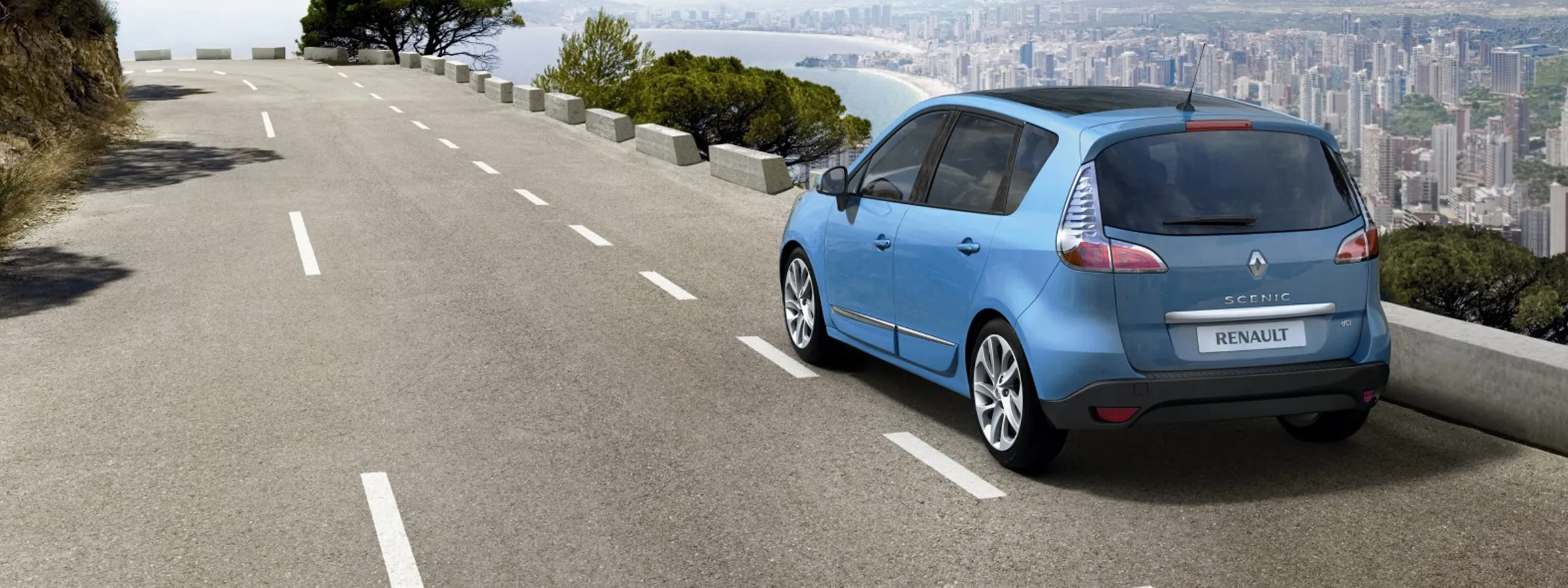 Renault Scenic car rental parked on a cliff road overlooking a coastal city skyline.