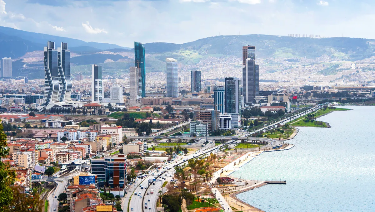 Horizon de la ville d'Izmir avec de hauts bâtiments le long de l'autoroute côtière, parfait pour la location de voitures en Turquie.