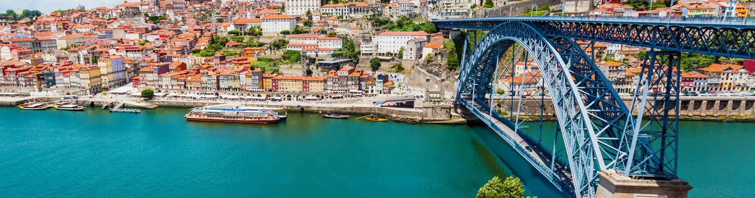 Vue de la ville de Porto avec le pont Dom Luís I sur le fleuve Douro, lieu fréquenté pour la location de voitures.