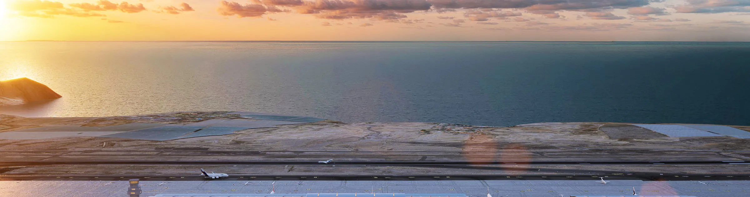 Flughafenlandebahn mit Flugzeugen nahe der Küste bei Sonnenuntergang.