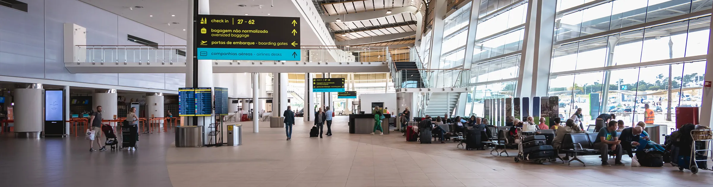 Luchthaven terminal met wachtende passagiers en borden voor inchecken en instapgate.