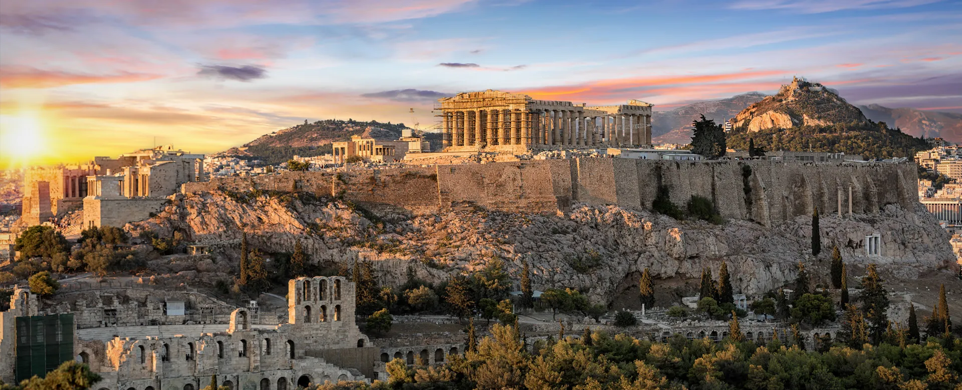 Akropolis v Athénách při západu slunce s antickými ruinami a městskou scenérií k pronájmu auta.