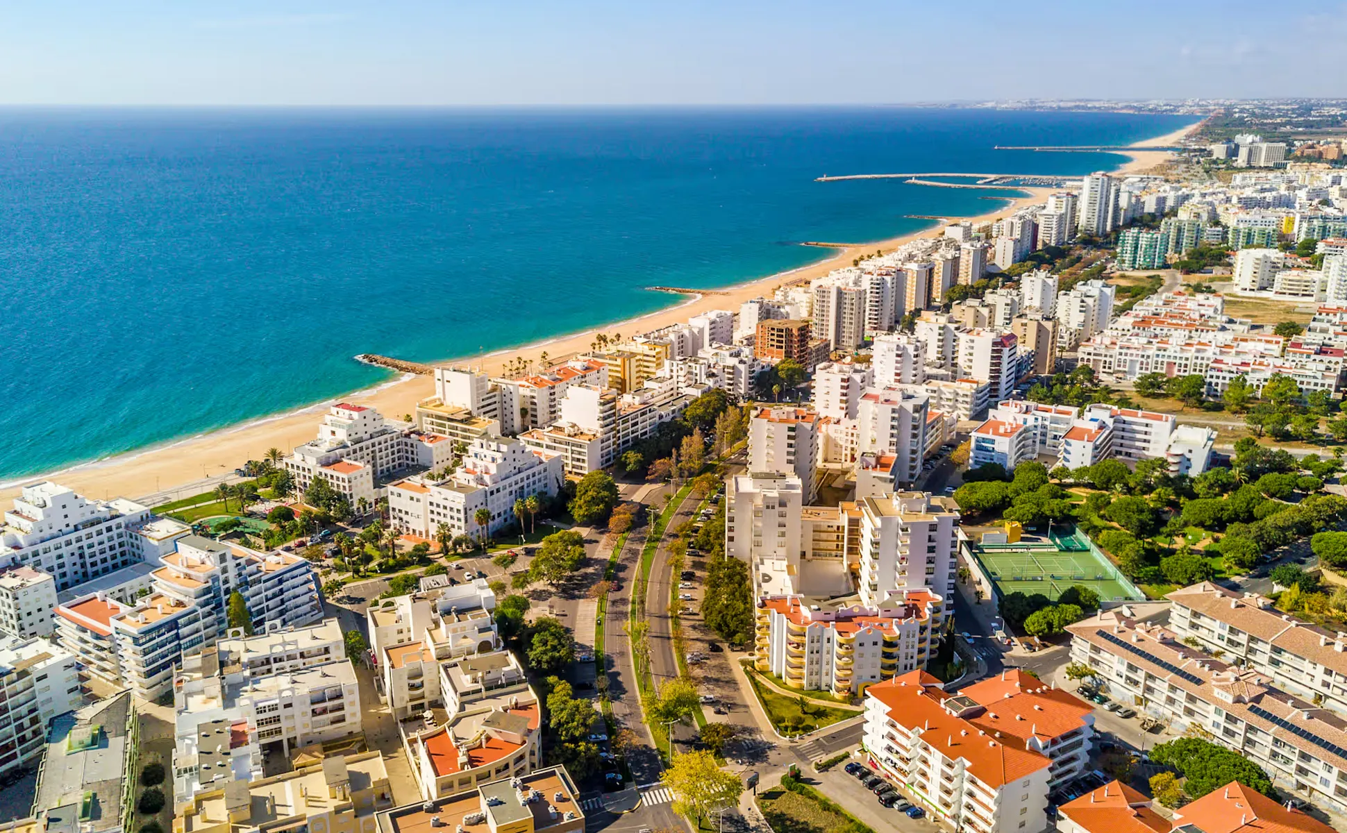 Lagos coastline in Algarve, Portugal with sandy beaches and urban buildings near the sea.