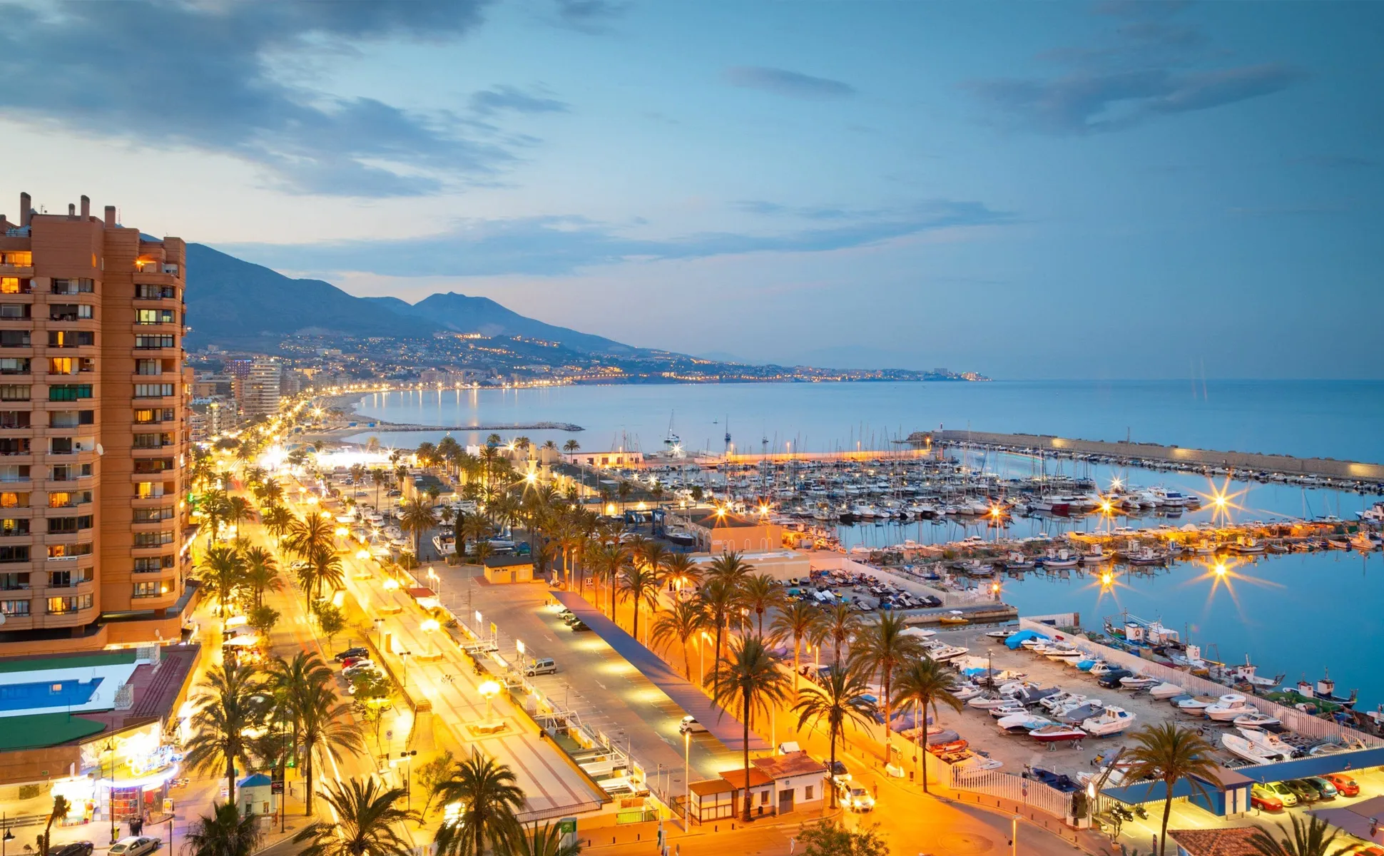 Alicante coastline and marina with city lights glowing at dusk, perfect for car rental travel.