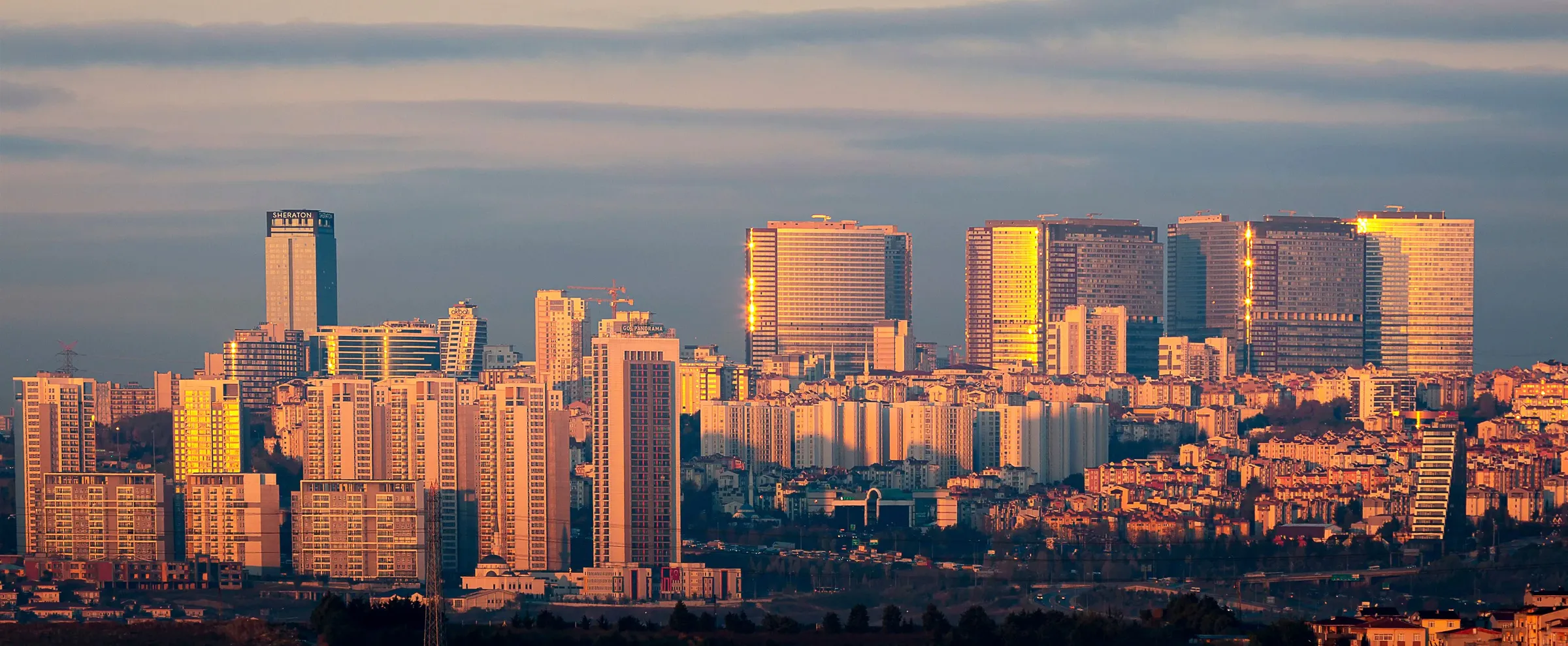 Ankara şehir silueti, güneş batarken modern yüksek binalar altın ışığı yansıtıyor.
