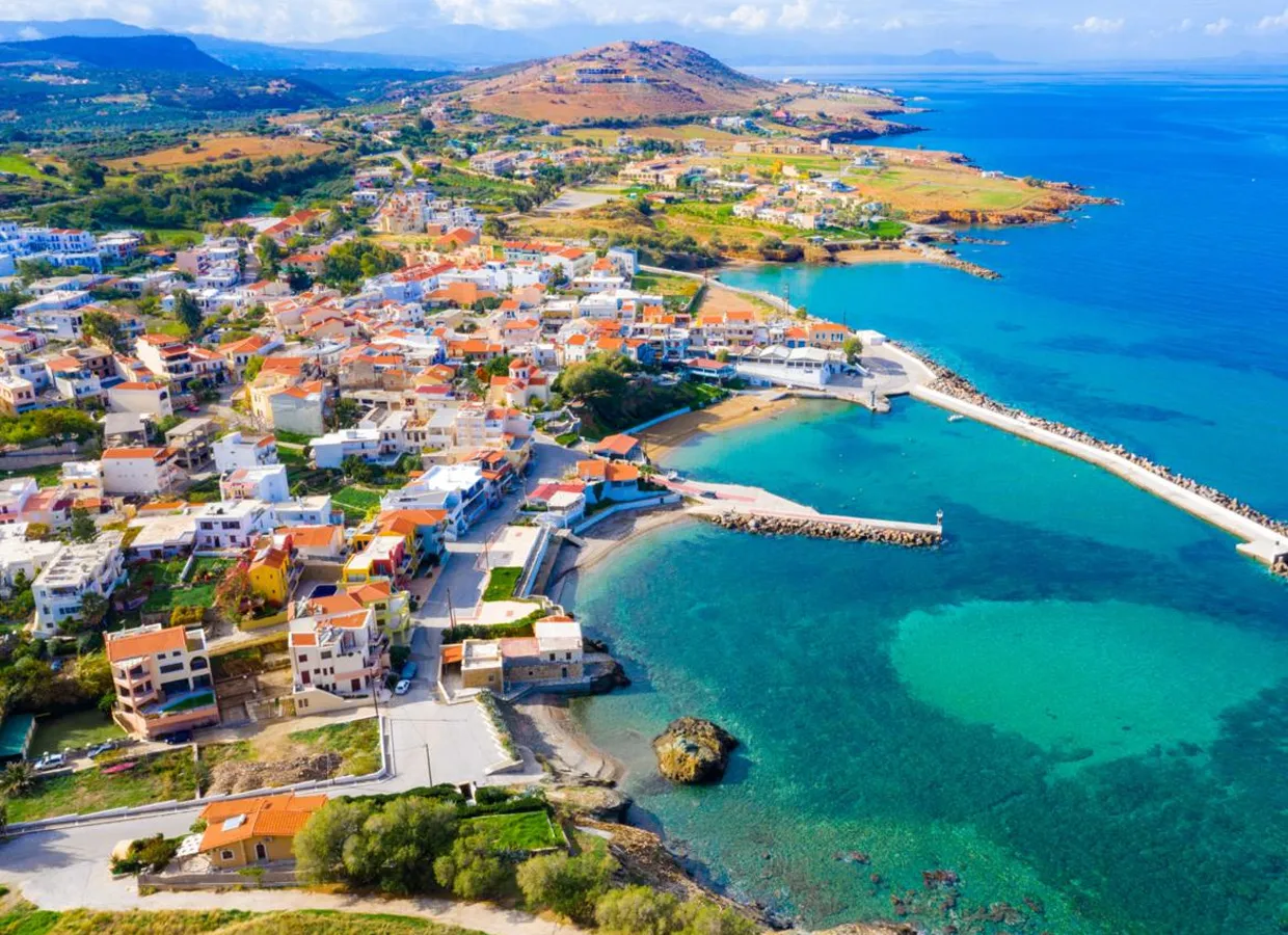 Agios Nikolaos coastal town with turquoise waters and scenic hills in Crete, Greece for car rental travelers.