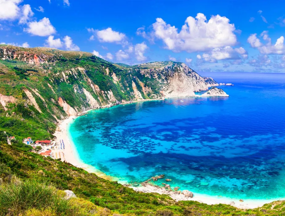 Greece beach with turquoise water and rugged cliffs, ideal for scenic car rentals and coastal drives.