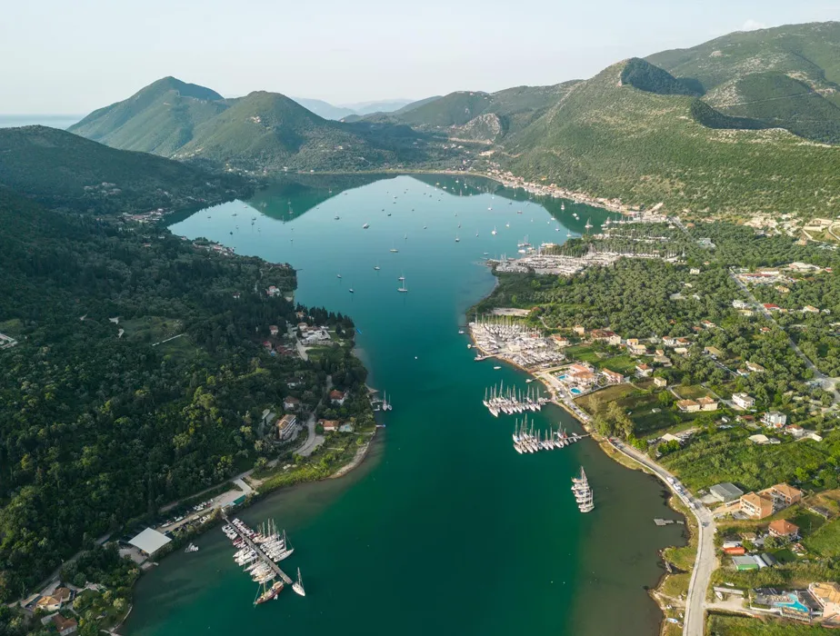 Corfu bay with boats and green hills, ideal scenery near car rental locations.