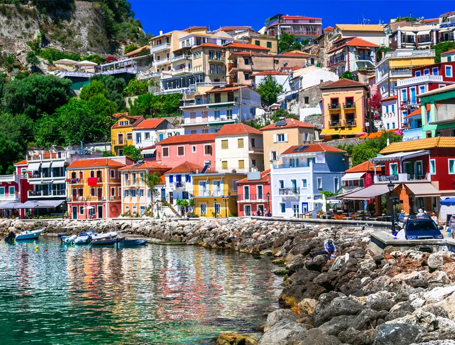 Colorful houses by the waterfront in Parga, Greece, popular spot for car rental and travel.