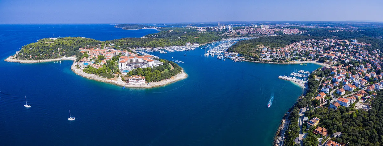Pula peninsula with marinas and residential buildings along the Adriatic coast.