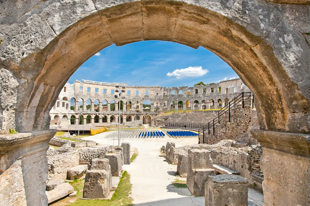 Pula Arena in Croatia, a historic Roman amphitheater under a clear blue sky.