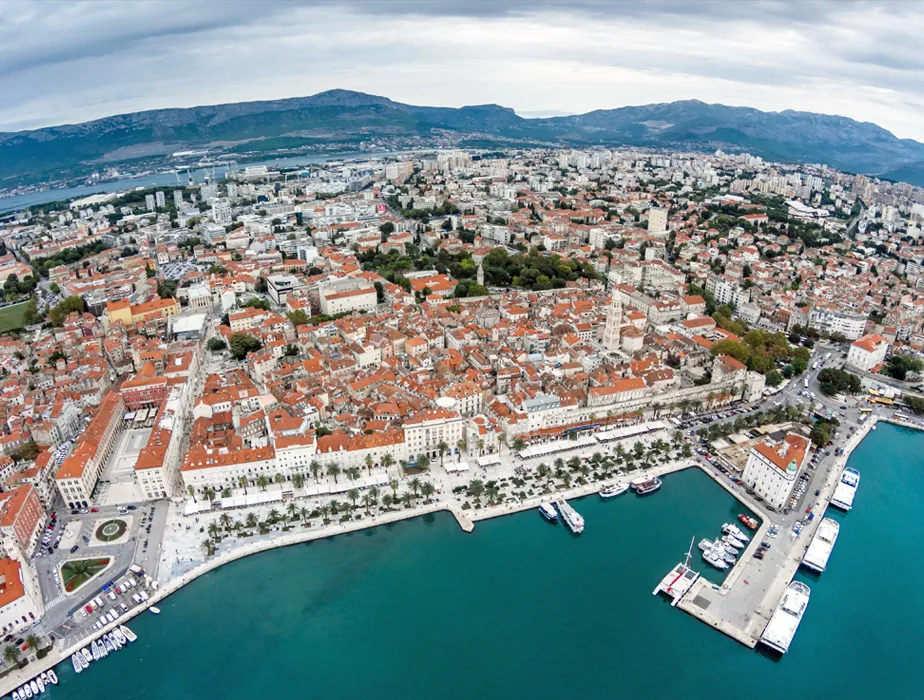 Split city of Split, Croatia, aerial view of the old town coastline and harbor with mountains in background.