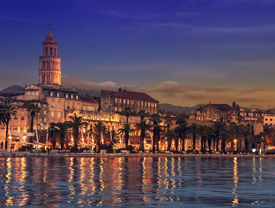 Split historic waterfront with palm trees and cathedral tower at dusk, Croatia car rental location.